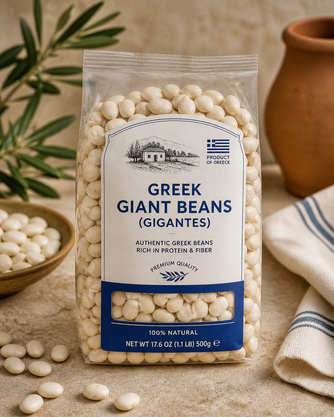 Bag of authentic Greek giant beans (Gigantes) in clear packaging with blue and white label, displayed on a rustic countertop with scattered beans, olive branches, and a terracotta vase in the background.